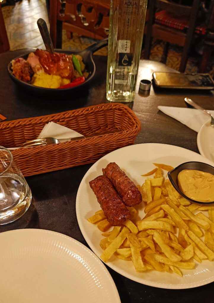 Comer un plato típico rumano, como los mici cu mustard de la foto, es algo que tienes que hacer en Bucarest en 1 día.